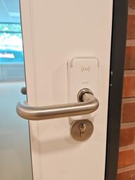 Bild eies weißen elektronischen Türbeschlags mit der Klinke nach links. Oberhalb der Klinke befindet sich ein Lesefeld für Schlüsselkarten.